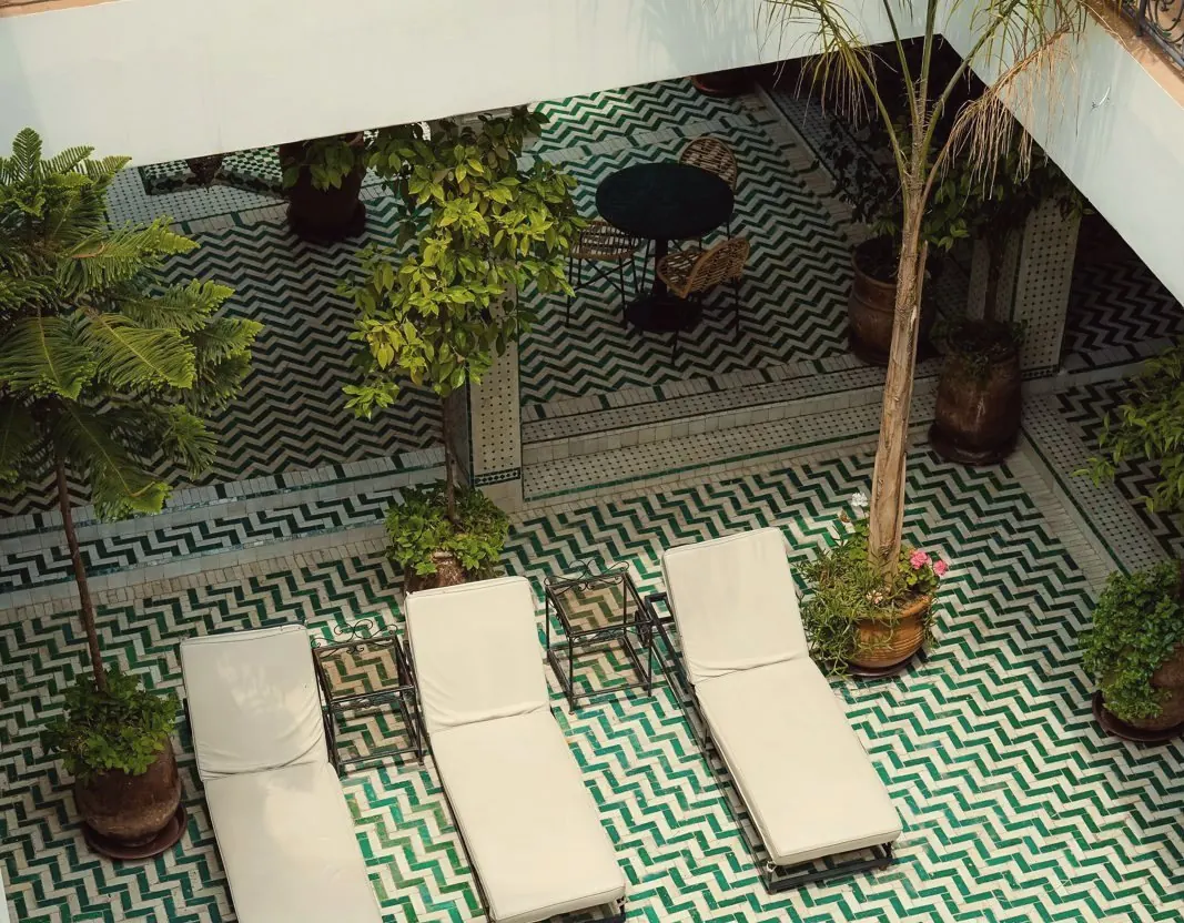 Patio d'un riad marocain avec zellige vert et bassin